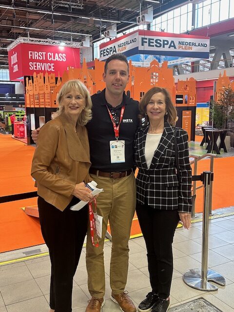 Cris Saunders & Greg Farmer from Insta Graphic Systems smiling at the 2024 FESPA Show, with exhibition banners in the background.